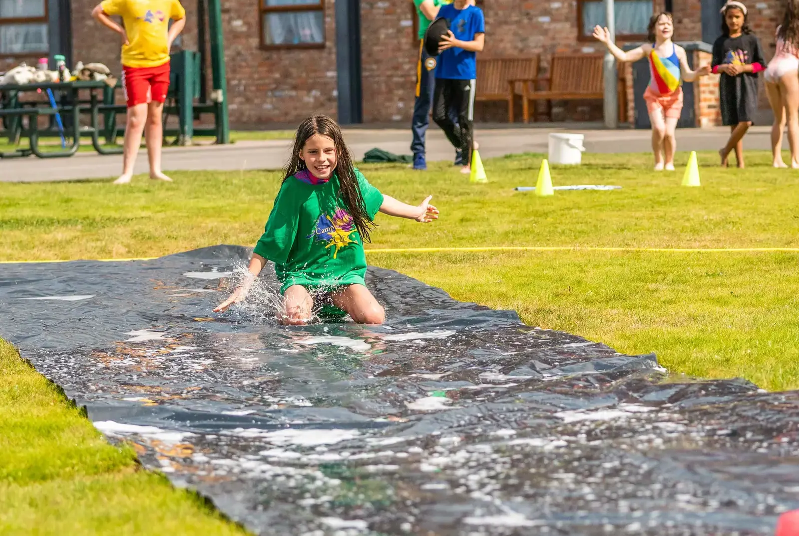 Children having fun on a water slide at Camp QE