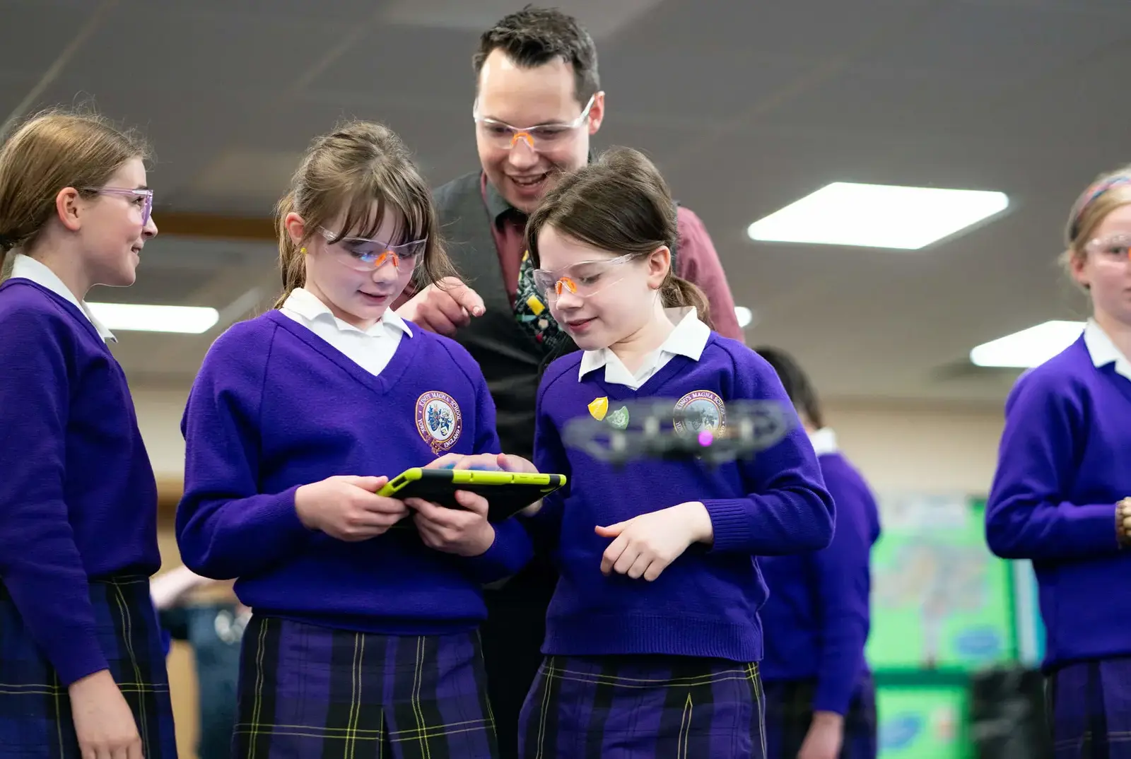 Three King's Magna girls learning to use coding to move a drone.