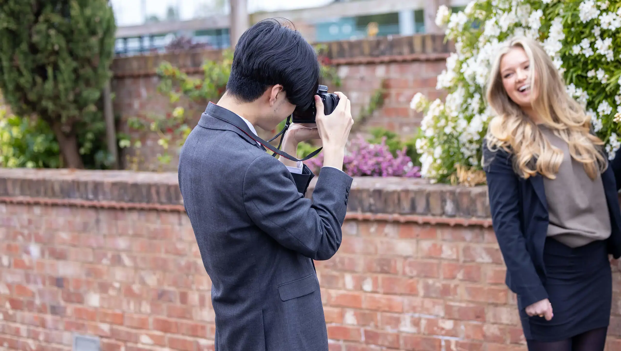 Senior school pupil taking a photograph of another pupil