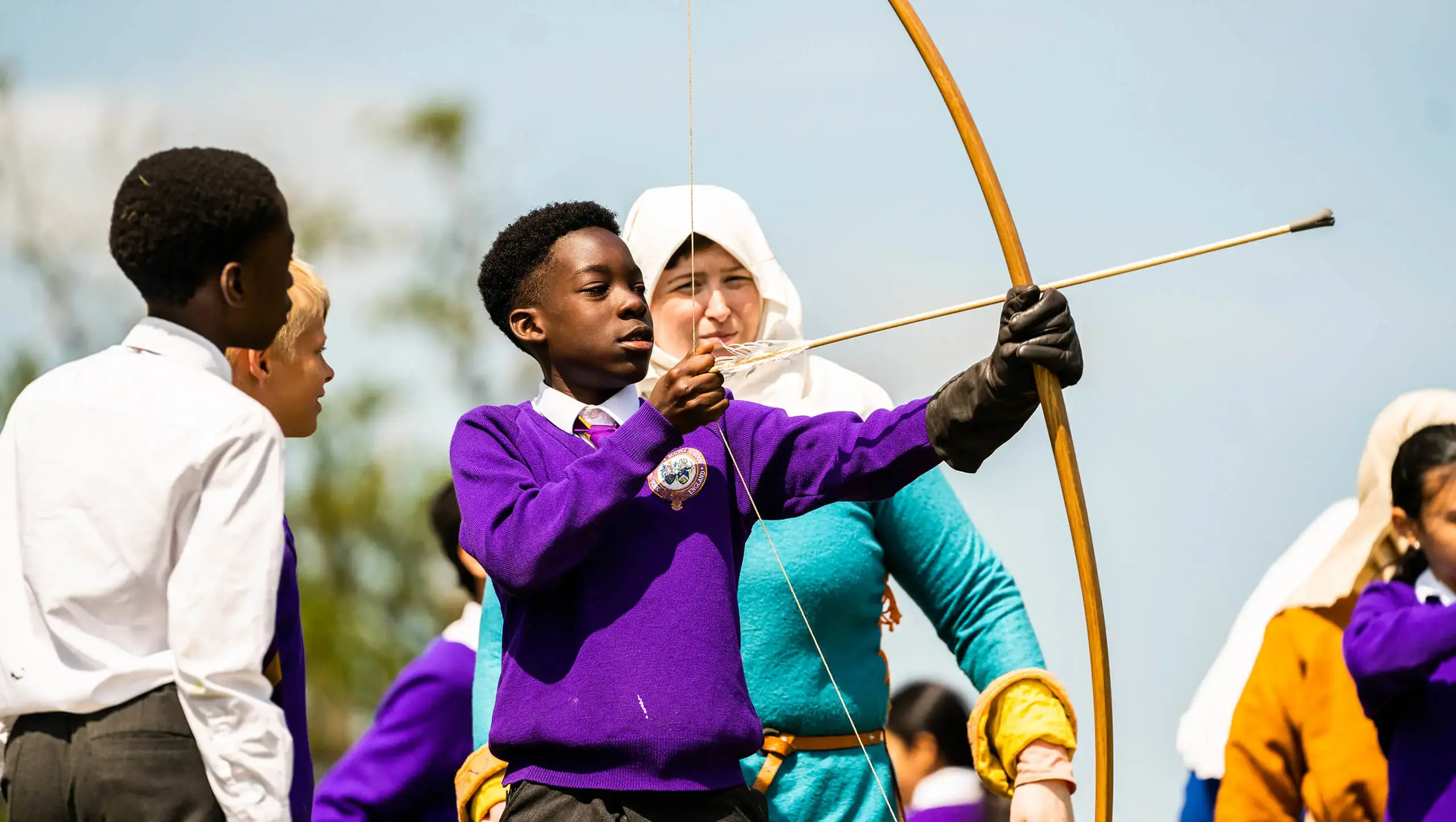King's Magna pupil shooting a bow and arrow