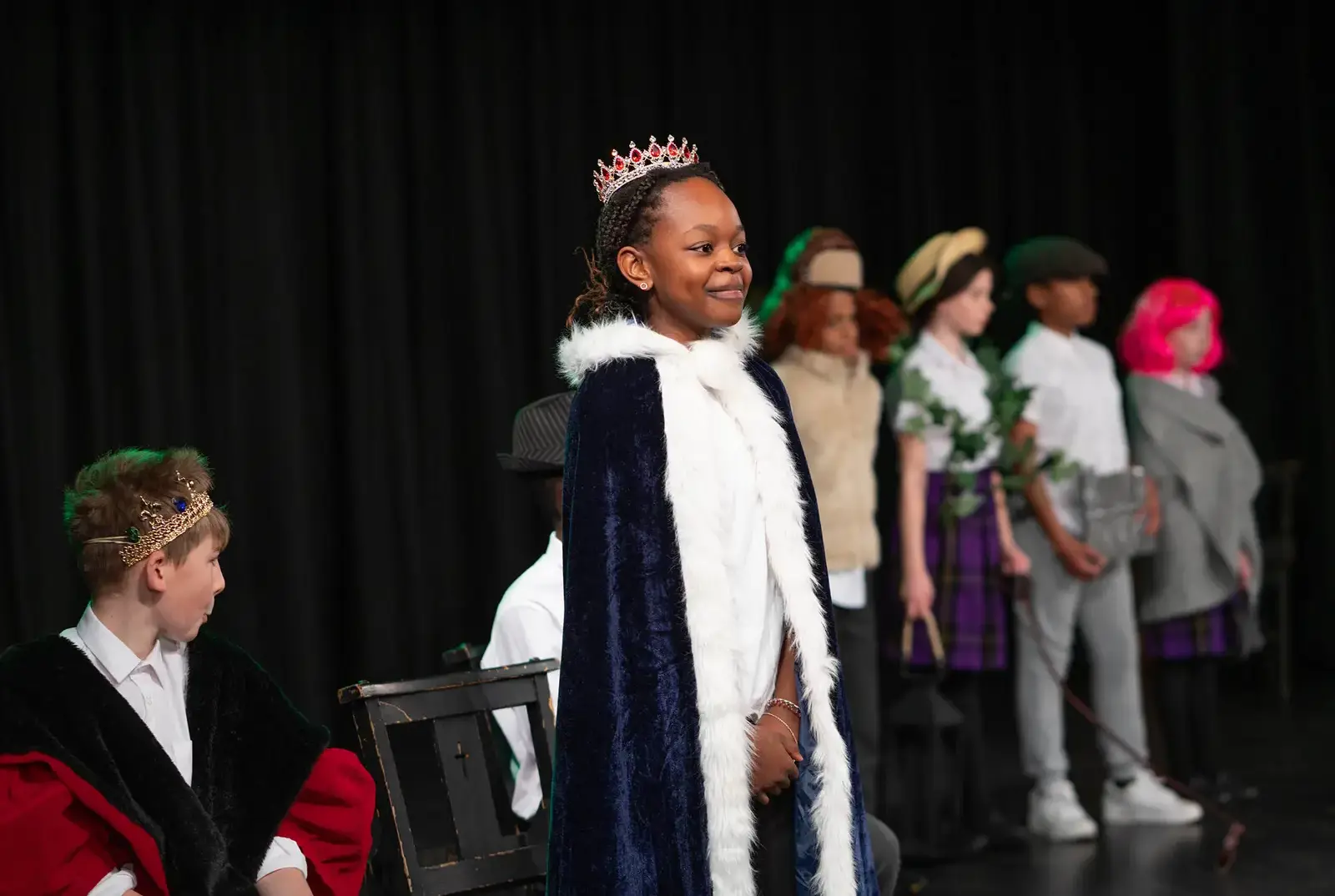 King's Magna pupil performing on stage in a dramatic production at Queen Ethelburga's Collegiate