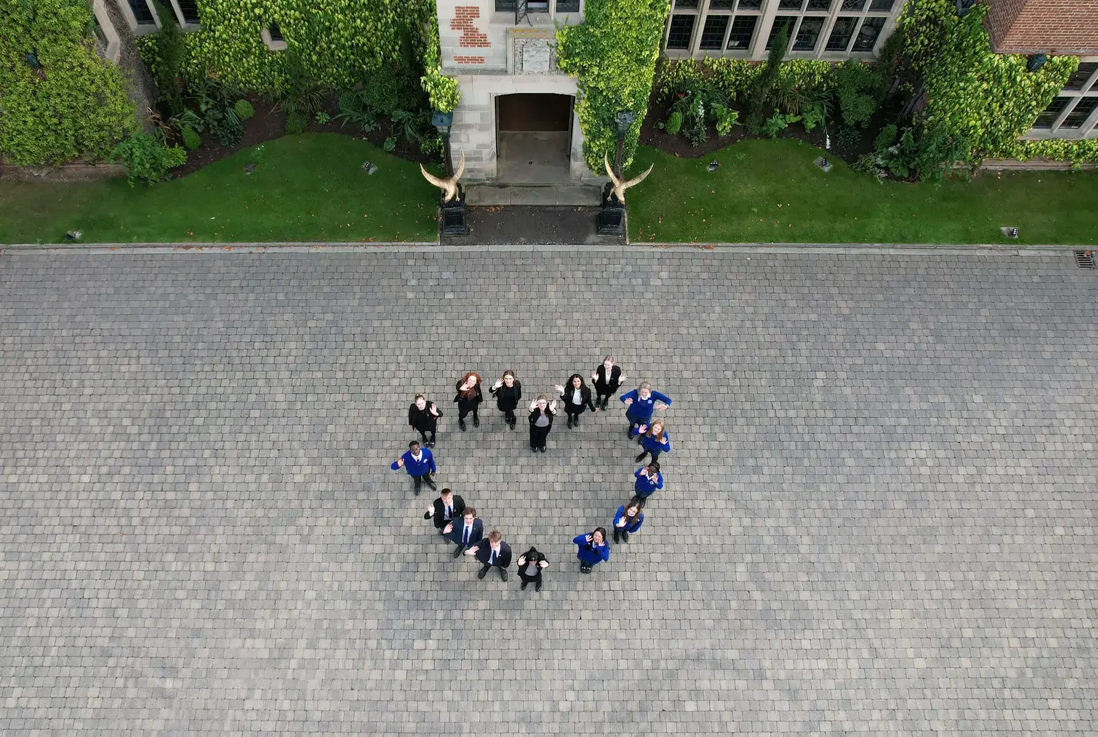 Aerial photo of QE students in the school yard standing in a heart shape