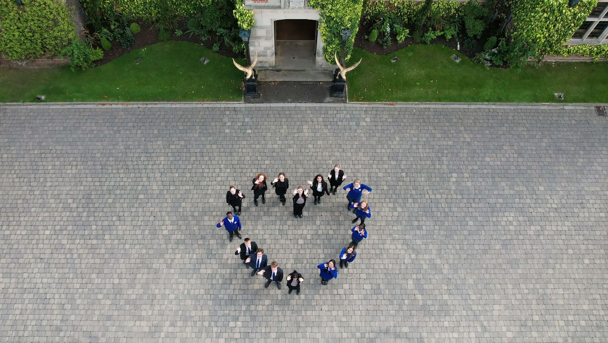Pupils standing in a heart shape in the school grounds