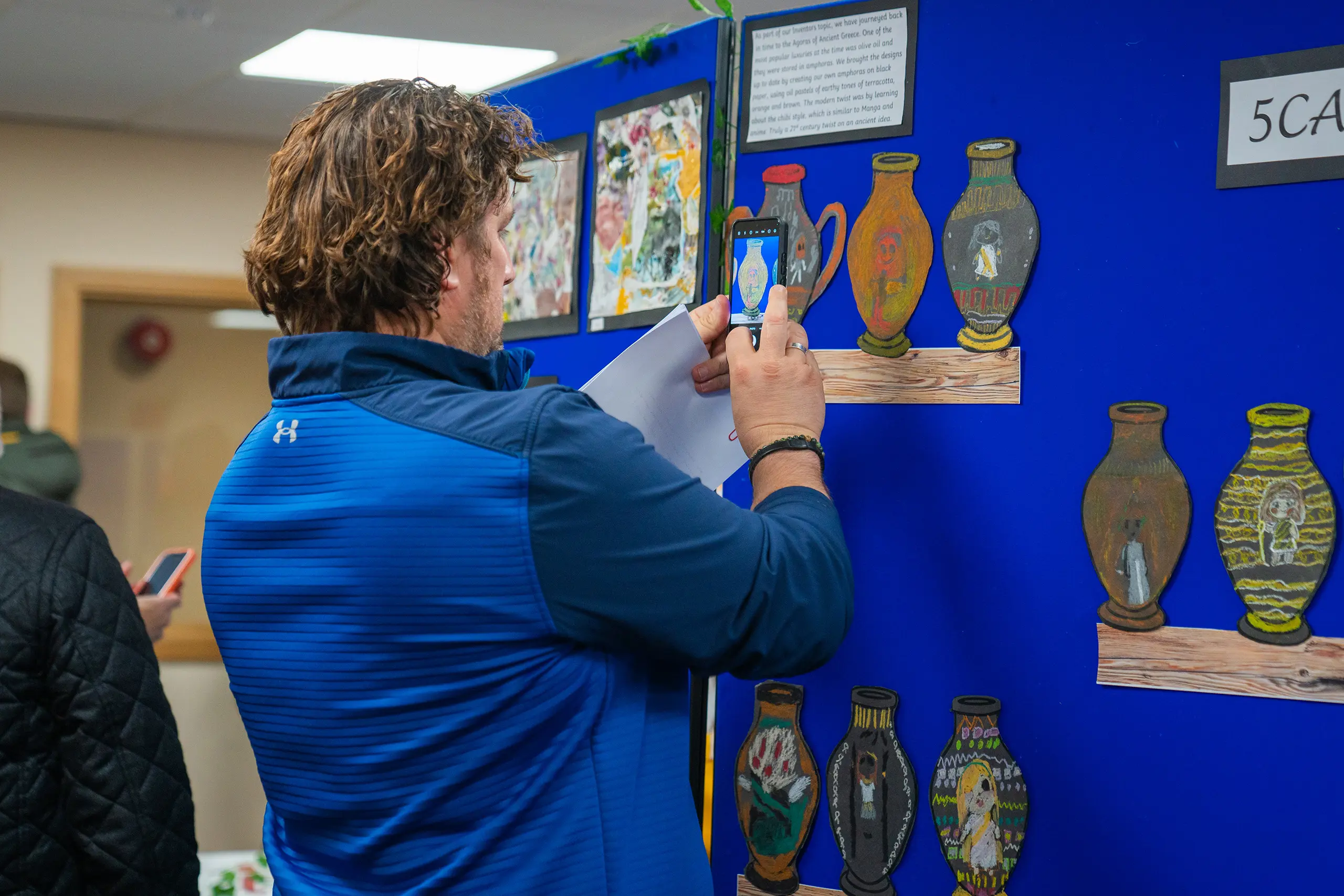 Parent taking a picture of their child's work.