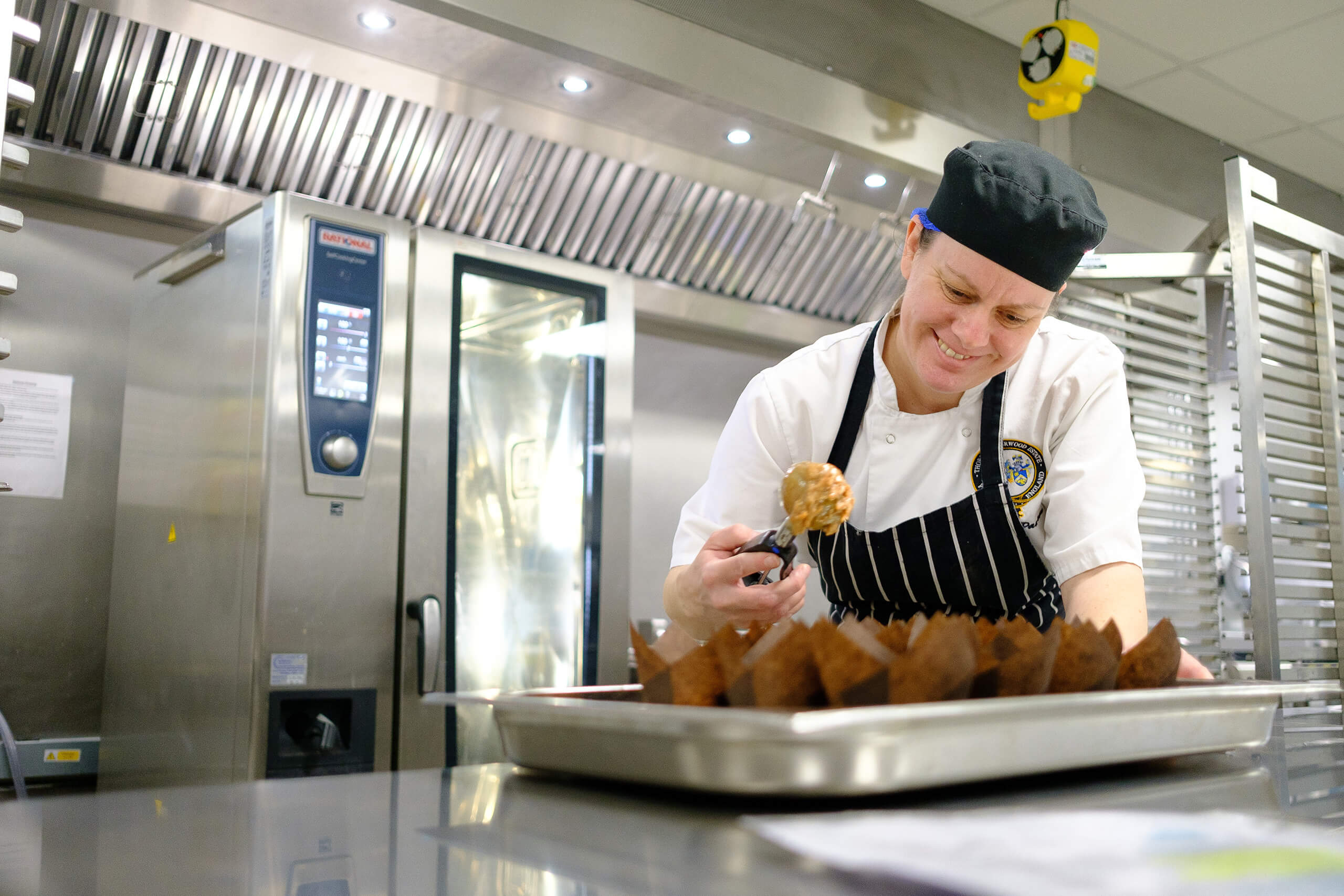 A member of the catering team making cupcakes.