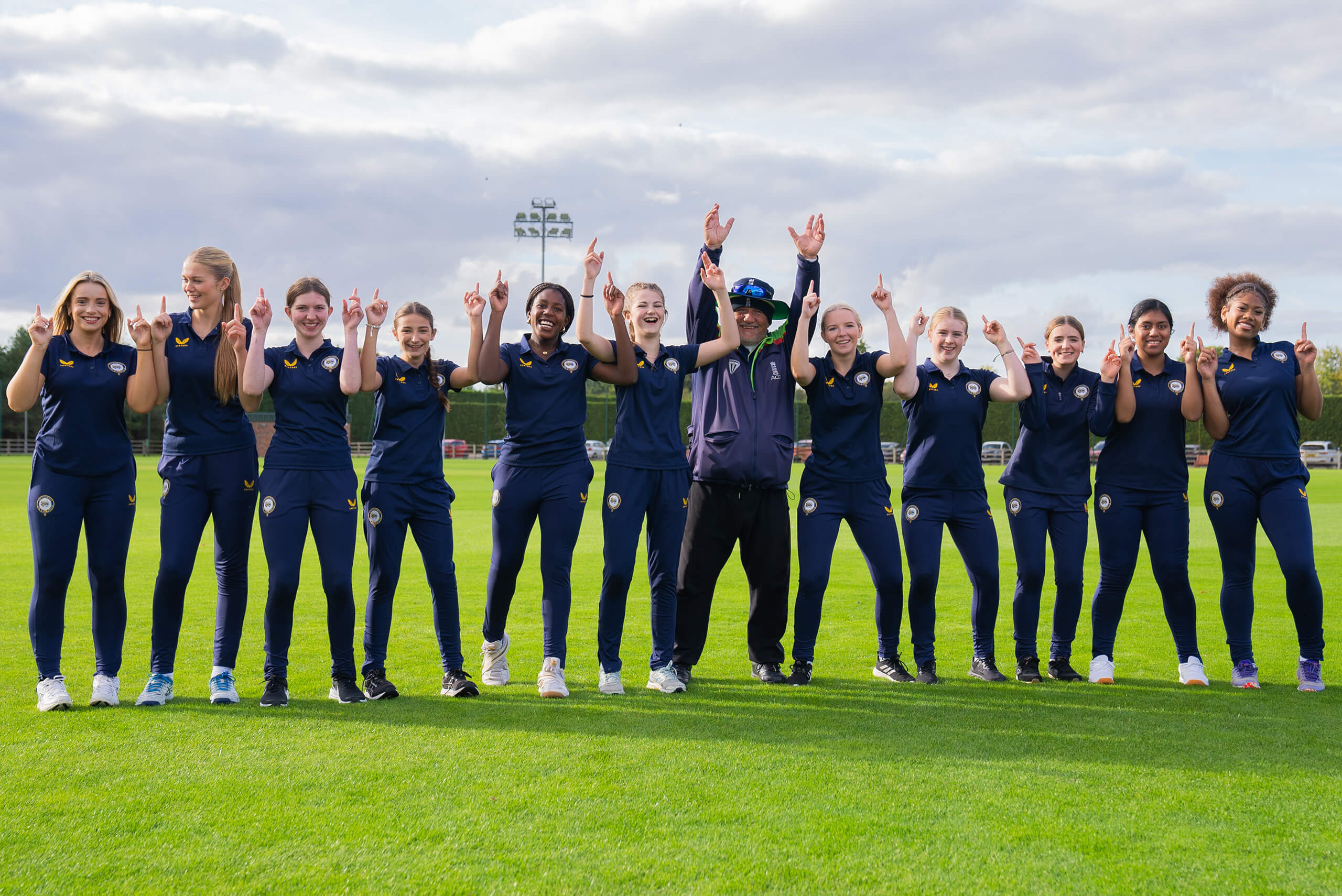 Girls cricket team celebrating a win.