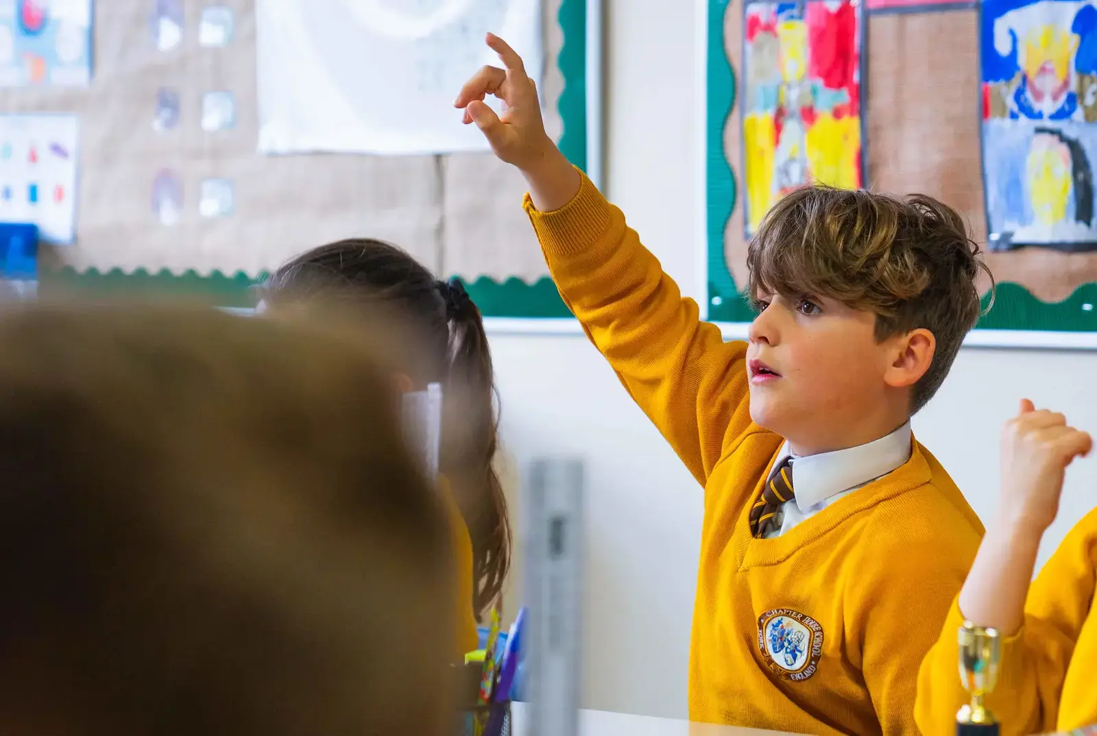 Chapter House student in a lesson with his hand up.